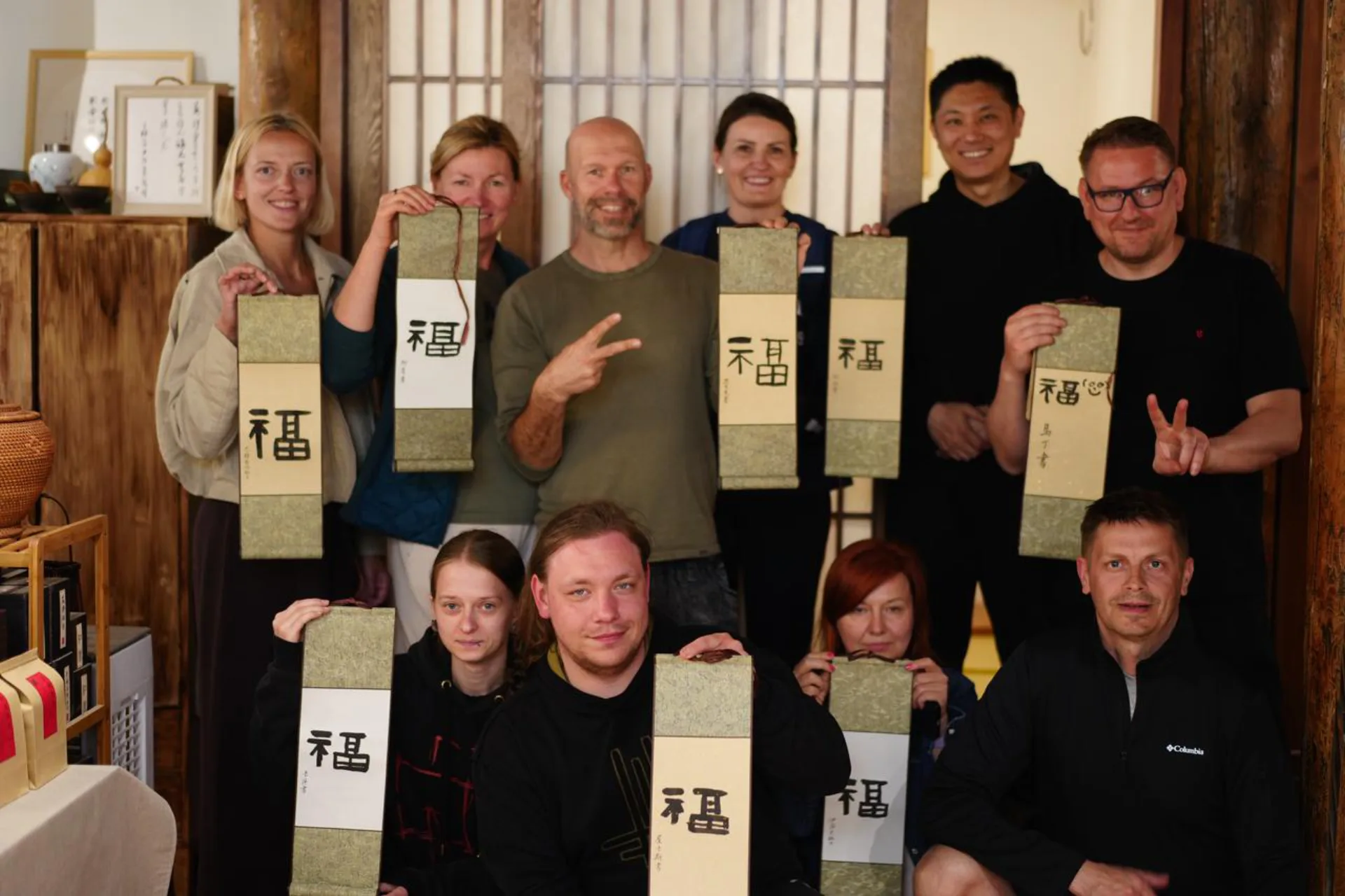 Group of international travelers with handmade Chinese calligraphy scrolls